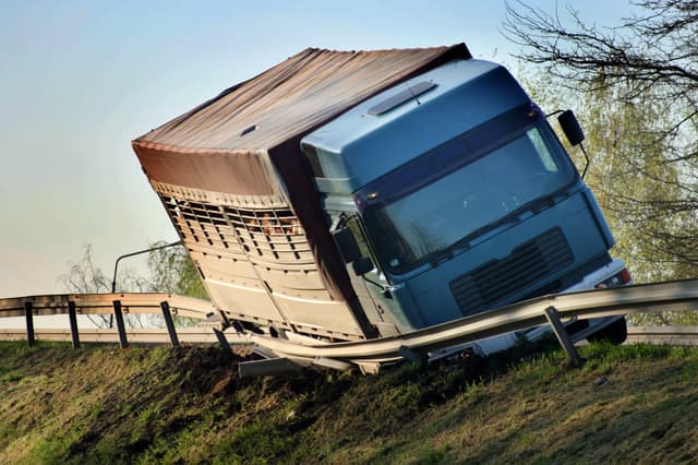 Truck losing control on a road, crashing into a guard rail.